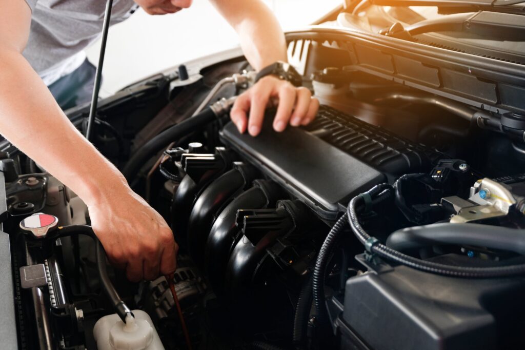 Car maintenance technician He is checking the auto engine, car inspection center.